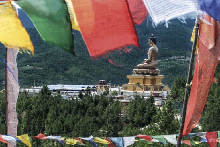 La gran estatua Buda Dordenma, punto de referencia de la ciudad de Thimphu. En primer plano, banderas de oración.