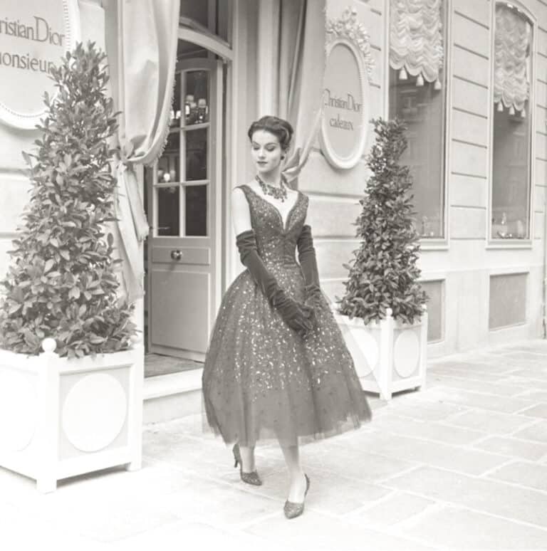 Modelo posando frente a 30 Montaigne con el vestido Diablotine, en 1957. Foto: Cortesía Dior (Association Willy Maywald, AGDP, París).
