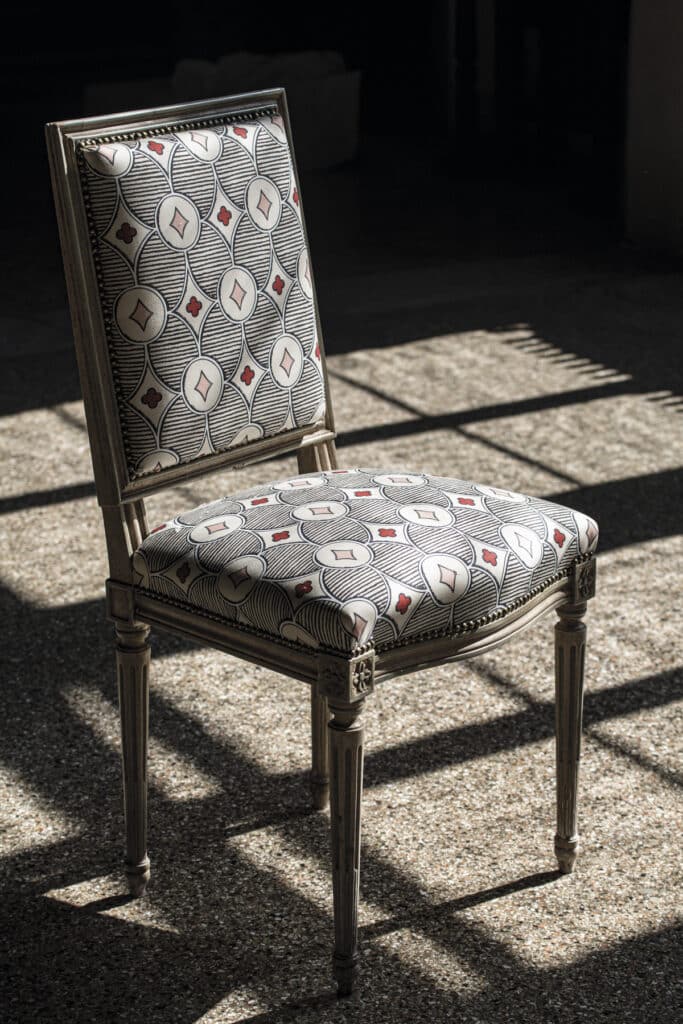 Silla tapizada con la tela de algodón estampada Quatrefoli, diseñada por Hall para la compañía italiana Rubelli. 