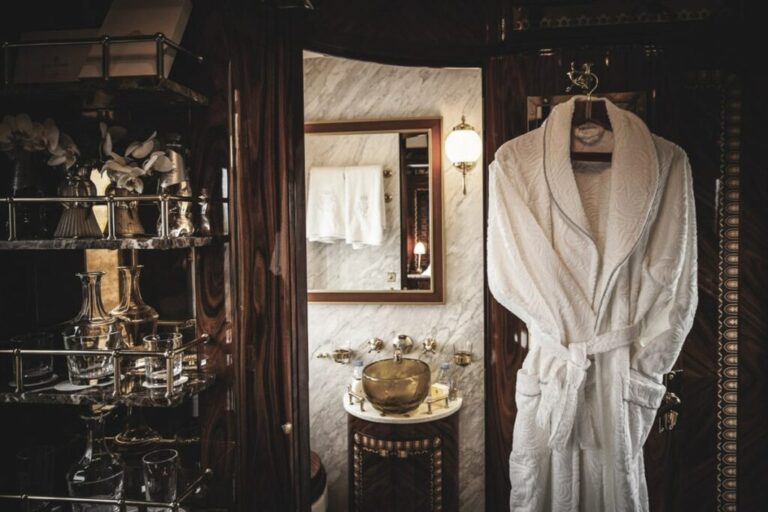 Detalle de una de las suites, que cuentan con baño privado y un sofisticado mueble bar en madera y cristalería de lujo.