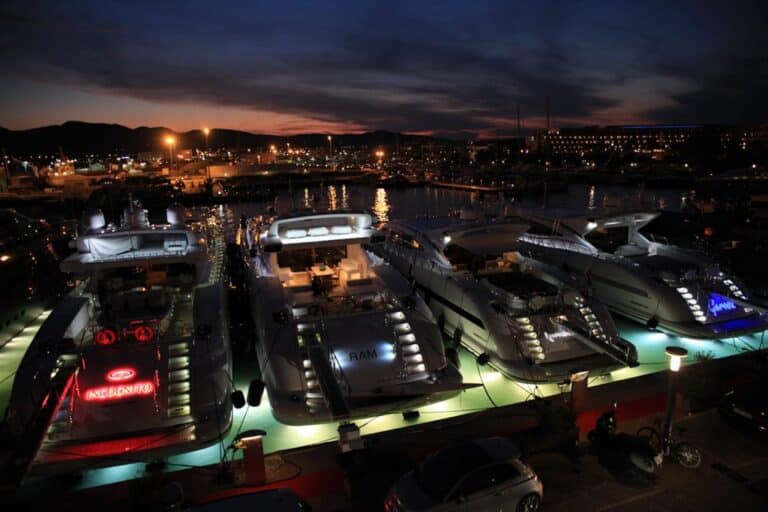 Por la noche, Marina Ibiza se convierte en una pasarela flotante y en una fiesta de luces y color.