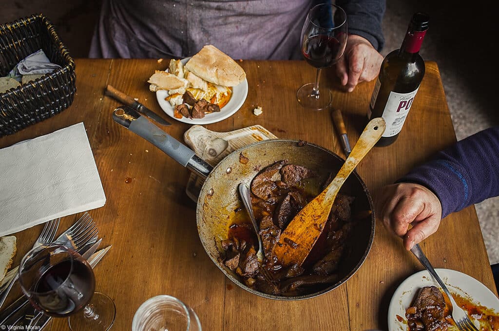 Pork, laughter, and red wine, fotografía de Virginia Morán, primer premio en la categoría ‘Food at the Table’ del concurso Pink Lady® Food Photographer of the Year 2024.