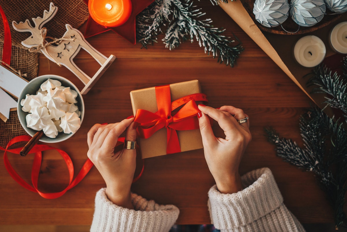 Mujer envolviendo un regalo de Navidad.