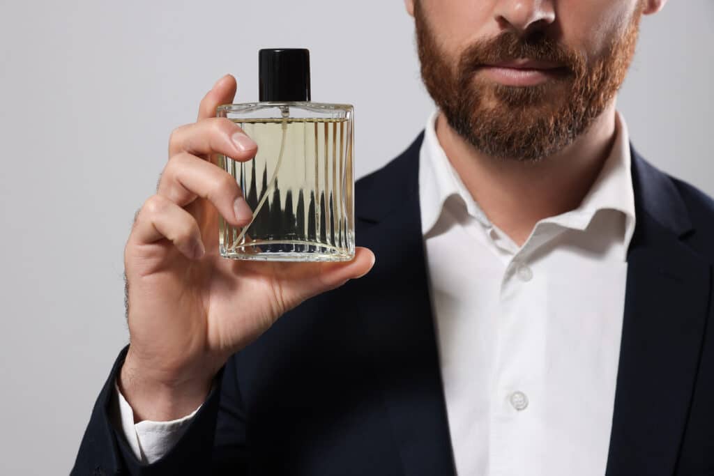 Hombre con frasco de perfume.