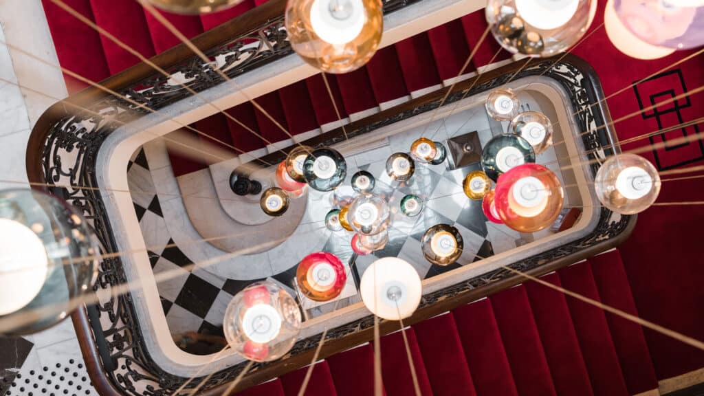 El 'chandelier' que preside la monumental escalera se ha convertido en uno de los símbolos del hotel Villas Foch.