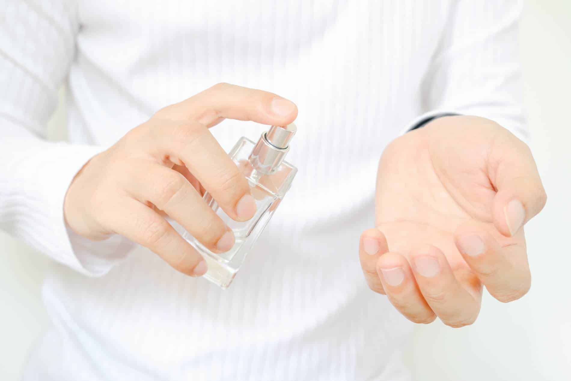 Hombre poniéndose perfume.